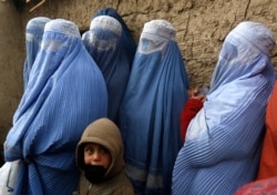 Perempuan Afghanistan berbaris untuk menerima bantuan bantuan musim dingin yang disumbangkan oleh Program Pangan Dunia (WFP) di sebuah kamp pengungsi di Kabul 13 Januari 2015. (Foto: REUTERS/Omar Sobhani)