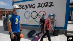 到河北省张家口崇礼的游客走过北京2022冬季奥运会的广告牌。（美联社 2020年8月13日）