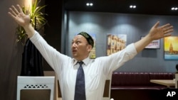 奥米尔贝卡利在哈萨克斯坦首都阿拉木图接受采访时展示他在中国当局的拘留营里是怎样被吊起来的。(2018年3月29日)