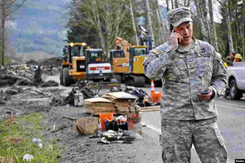 Chief Warrant Officer Kevin Crisp, liaison officer for the Washington National Guard, coordinates the arrival of a search team at the site of the mudslide in Oso, Washington, March 26, 2014.