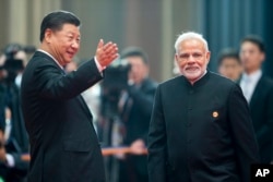 中国国家主席习近平欢迎印度总理莫迪来到上海合作组织举行于中国山东省青岛市的峰会。2018年6月10日。