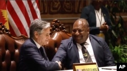 2023年5月22日，美国国务卿安东尼·布林肯（左）和巴布亚新几内亚国防部长温·巴克里·达基（右）在签署安全协议后握手。（美联社照片）