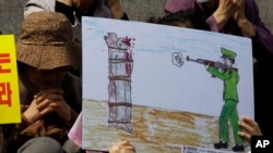 FILE - A defector reacts to a drawing depicting public execution of a North Korean soldier during a human rights rally in Seoul, South Korea, April 14, 2011.