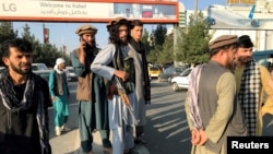 塔利班成员站在哈米德·卡尔扎伊国际机场外。(2021年8月16日)