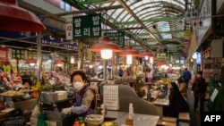 A vendor waits for customers at a market in Seoul on April 20, 2020. 