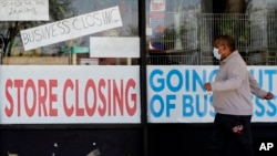Čovek prolazi pored izloga prodavnice u Ilinoisu, koja ne radi zbog Kovida 19 (Foto: AP)