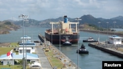 FILE - Cargo vessels transit through the Panama Canal, on the outskirts of Panama City, Panama, April 19, 2023.