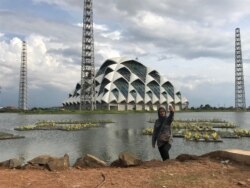 Seorang wanita berfoto di Embung Gedebage, Kota Bandung, yang berdampingan dengan Masjid Raya Jawa Barat. Bersama dua proyek lainnya, embung ini dibuat untuk kendalilan air di Bandung Raya.