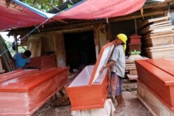 Suherman (45), membuat peti jenazah untuk jenazah pasien Covid-19, di sebuah tempat pemakaman di Jakarta, 8 April 2020. (Foto: Reuters)