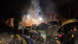 抗议者在香港中文大学与警察冲突之际躲在他们竖立的障碍后。(2019年11月12日)