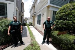 Petugas polisi berdiri di luar rumah mantan polisi Minneapolis Derek Chauvin, yang menekan lutut di leher pria Afrika-Amerika George Floyd sebelum kematiannya.(Foto: Reuters/Scott Audette)
