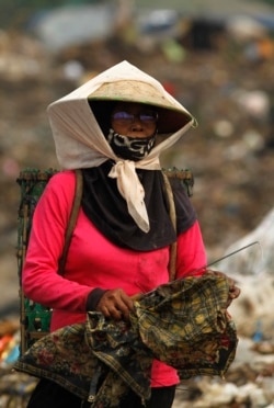 Seorang pemulung mengumpulkan plastik dan kertas untuk didaur ulang di tempat pembuangan sampah utama Bantar Gebang di Kabupaten Bekasi, 10 Oktober 2011. (Foto: REUTERS/Beawiharta)