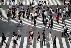 Warga mengenakan masker saat menyebrang jalan di Shibuya, Tokyo, 9 Juli 2020.