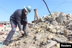 A member of a counter-radiation team uses a Geiger counter to search for missing radioactive material in Basra, Iraq, February 21, 2016.