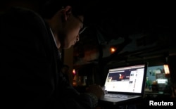 FILE - Vietnamese internet activist Nguyen Lan Thang posts a status on Facebook at a cafe in Hanoi, Nov. 27, 2013. Vietnam will hand out fines of 100 million dong ($4,740) to anyone criticizing the government on social media, under a new law announced this week, the latest measure in a widening crackdown on dissent by the country's communist rulers.