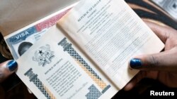 Seorang perempuan menunjukkan paspornya dan visa AS di Accra, Ghana, 1 Februari 2019. 