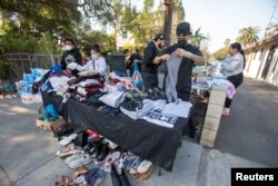 People gather to distribute water and clothing to victims of the Eaton Fire in Altadena, California, on Jan. 10, 2025.