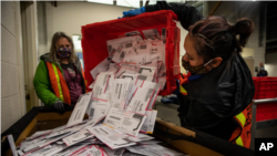 资料照片：2020年11月3日，选举工作人员在俄勒冈州波特兰市清空投票箱中的选票。（美联社照片）