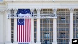 Para pekerja memasang bendera di bagian West Front Gedung Kongres AS sebagai persiapan upacara pelantikan Presiden terpilih Joe Biden, Sabtu, 9 Januari 2021. 