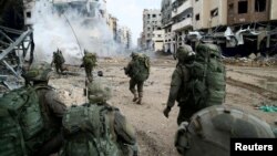 以色列国防部2023年12月18日发表照片显示，以色列士兵在加沙地带行进。