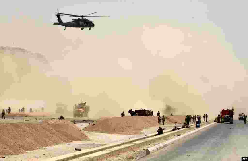 A U.S. Black Hawk helicopter flies over the site of a Taliban attack in Kandahar, Afghanistan. A suicide bomber rammed a vehicle filled with explosives into a convoy of foreign forces in the country's restive southern province, causing casualties, officials said.