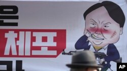 Karikatura koja prikazuje južnokorejskog predsednika u blizini sedišta vladajuće Partije Narodne moći u Seulu, Južna Koreja, u ponedeljak, 9. decembra 2024. (AP Photo/Lee Jin-man)