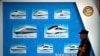 FILE - A security official stands near a display showing different models of Chinese trains ahead of the 2018 Forum on China-Africa Cooperation in Beijing, Aug. 30, 2018. Chinese funds for projects like railroads have flooded into Africa in recent years.