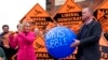 Newly elected Liberal Democrat lawmaker Helen Morgan, left, bursts a "Boris' bubble" held by colleague Tim Farron, as she celebrates in Oswestry, Shropshire, England, Dec. 17, 2021.