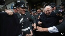 Pastor Fernando Karadima (tengah) dikawal dari gedung pengadilan setelah memberi kesaksian dalam sidang gugatan hukum menutupi pelecehan seksual oleh Uskup Agung Santiago, 11 November 2015. 