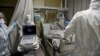 FILE - Medical workers wearing a personal protective equipment PPE tend to a patient infected with the Covid-19 at the intensive care unit of the Mariinsky Hospital in Saint Petersburg, Russia, July 7, 2021.