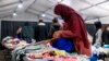 FILE - Afghan refugees pick out clothes at an Afghan refugee camp at Joint Base McGuire Dix Lakehurst, N.J., Sept. 27, 2021. 