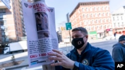 Seorang petugas polisi menggantung tanda yang menawarkan hadiah untuk informasi terkait orang yang menyerang seorang perempuan Amerika keturunan Asia di dekat TKP, Selasa, 30 Maret 2021, di New York. (AP Photo/Mary Altaffer)