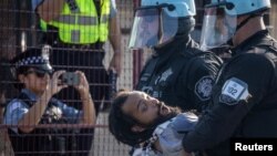 Policija privodi čoveka nakon što je nekoliko demonstranata probilo bezbednosnu ogradu u (Foto: REUTERS/Adrees Latif)