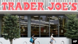People practice social distancing as they wait in line to enter a grocery store, April 7, 2020, in Miami Beach, Fla. 