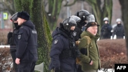 2024 年 2 月 17 日俄罗斯反对派领导人阿列克谢·纳瓦尔尼在北极死亡一天后，俄罗斯圣彼得堡警察抓捕前去政治镇压受害者纪念碑前给纳瓦尔尼献花的民众。图为一名男子被警察带走。