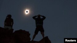 Tanner Person (R) dan Josh Blink, keduanya dari Vacaville, California, menyaksikan gerhana matahari dari Monumen Nasional John Day Fossil Beds, dekat Mitchell, Oregon, Amerika, 21 Agustus 2017. 
