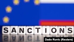 Slova na kojima piše "sankcije" ispred zastava Evropske unije i Rusije (ILUSTRACIJA: Reuters/Dado Ruvić)