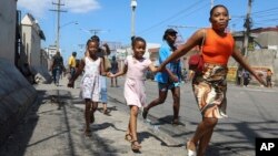 Moun Potoprens kouri kite kay yo pou chape zak vyolans gang yo nan katye Delmas, 25 Fevriye, 2025. 