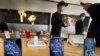 FILE - Staff members chat with customers at an Apple store in Beijing, Feb. 19, 2020. 
