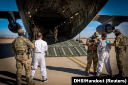 FILE - The first U.S. military aircraft to carry detained migrants to a detention facility at Guantanamo Bay is boarded from an unspecified location in the U.S., Feb. 4, 2025.