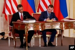 FILE - President Barack Obama, left, and Russian President Dmitry Medvedev sign the New START treaty at the Prague Castle in Prague, April 8, 2010.