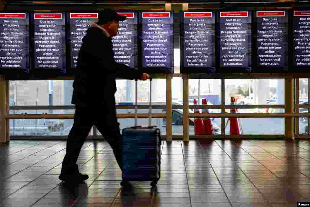 A person walks at Ronald Reagan Washington National Airport, in the aftermath of the collision of American Eagle flight 5342 and a Black Hawk helicopter that crashed into the Potomac River, in Arlington, Virginia, Jan. 30, 2025.