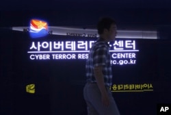 Seorang pria berjalan melewati papan nama di Cyber Terror Response Center Badan Kepolisian Nasional di Seoul, Korea Selatan, 16 Juli 2013. (Foto: AP)