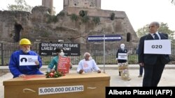 Aktivis Amnesty International, Emergency dan Oxfam menggelar demonstrasi flashmob untuk mengecam situasi ketimpangan akses vaksin di dunia, pada 29 Oktober 2021 di Piazza Vittorio di Roma menjelang KTT Pemimpin Dunia G20. (Foto: Alberto Pizzoli/AFP)