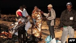 Di dân Libya được giúp đỡ khi đặt chân đến hòn đảo ở Lampedusa, Italia, sáng chủ nhật, ngày 8/5/2011