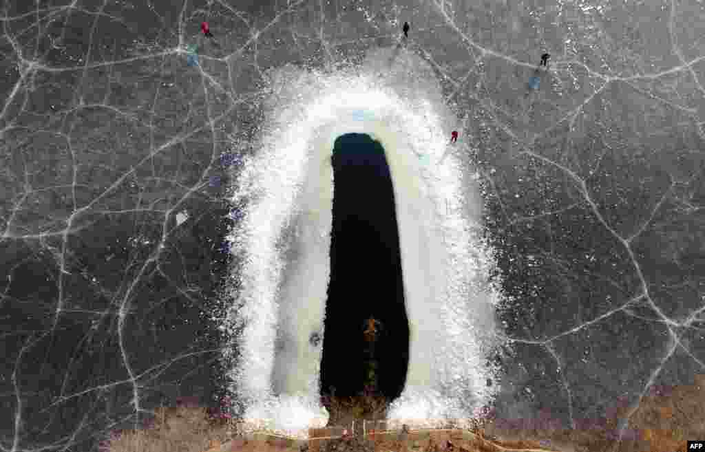 2019年1月11日，中国辽宁省沈阳的冻湖上开出了游泳池，有人冬泳。