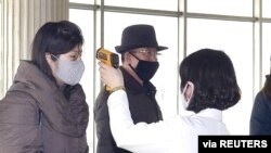 Petugas memeriksa suhu tubuh warga setempat dalam kampanye anti-virus corona di Pyongyang, Korea Utara, 4 Maret 2020. (Foto: KCNA via Reuters). 