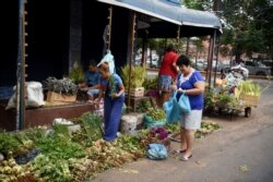 Women buy medicinal plants in Asuncion, Paraguay, on April 2, 2020.