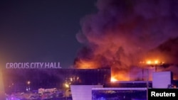 Asap membubung dari tempat konser Crocus City Hall menyusul laporan penembakan di luar Kota Moskow, Rusia, Jumat, 22 Maret 2024. (Foto: Maxim Shemetov/Reuters)