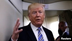 FILE - President Donald Trump talks to reporters aboard Air Force One at Joint Base Andrews outside Washington, May 13, 2017. In his flight to France this week, he spoke for an hour with journalists aboard the plane. He and French President Emmanuel Macron met for talks July 13, 2017.